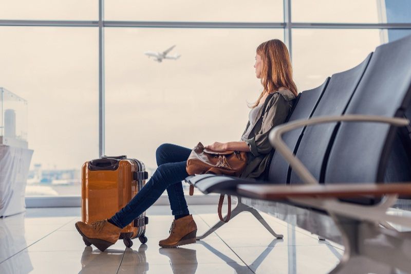 A female passenger is accepting and waiting for her flight 